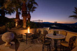 View of patio / terrace featuring area for grilling, a fire pit, outdoor dining area, and a mountain view