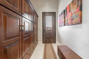 Doorway to outside featuring baseboards and tile patterned flooring