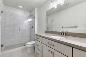 Full bathroom with vanity, a shower stall, a textured ceiling, and light tile patterned floors