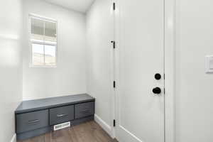 Mudroom with wood finished floors and baseboards
