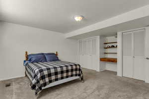 Bedroom with multiple closets and light carpet