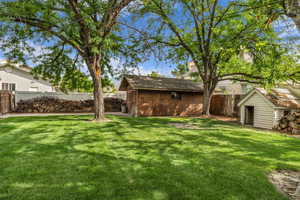 Fenced backyard featuring a shed