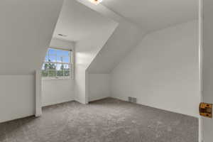 Bonus room with light carpet and lofted ceiling