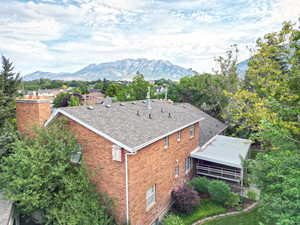 Aerial view of property and surrounding area with a mountainous background and a tree filled landscape