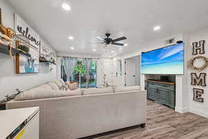 Living room with light wood finished floors, recessed lighting, and ceiling fan