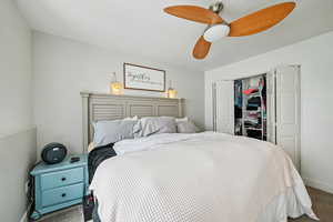 Carpeted bedroom featuring a closet and a ceiling fan