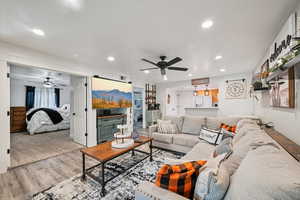 Living room with recessed lighting, wood finished floors, and a ceiling fan