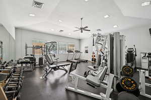 Workout area with ceiling fan and vaulted ceiling