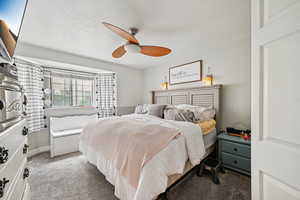 Bedroom featuring carpet, a textured ceiling, and ceiling fan