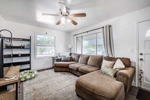 Living area featuring wood finished floors and a ceiling fan