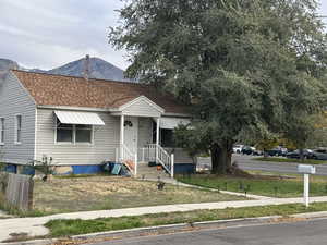 Bungalow with roof with shingles and a front lawn