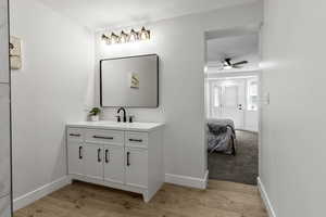 Bathroom with vanity, light wood-style floors, and a ceiling fan