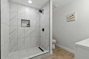 Full bathroom featuring a stall shower, light wood finished floors, vanity, and recessed lighting