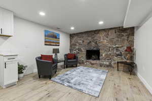 Living area featuring a fireplace, light wood-style flooring, and recessed lighting