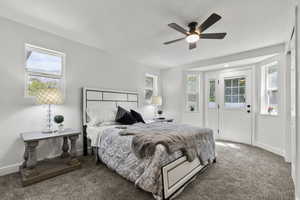 Carpeted bedroom featuring multiple windows and a ceiling fan