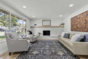 Living area with a fireplace, light wood finished floors, and recessed lighting