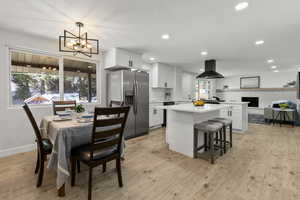Dining space with light wood-style flooring, recessed lighting, and a chandelier