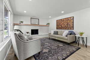 Living room featuring a fireplace, light wood-style flooring, and recessed lighting