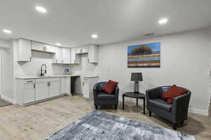 Living area with light wood-style flooring and recessed lighting