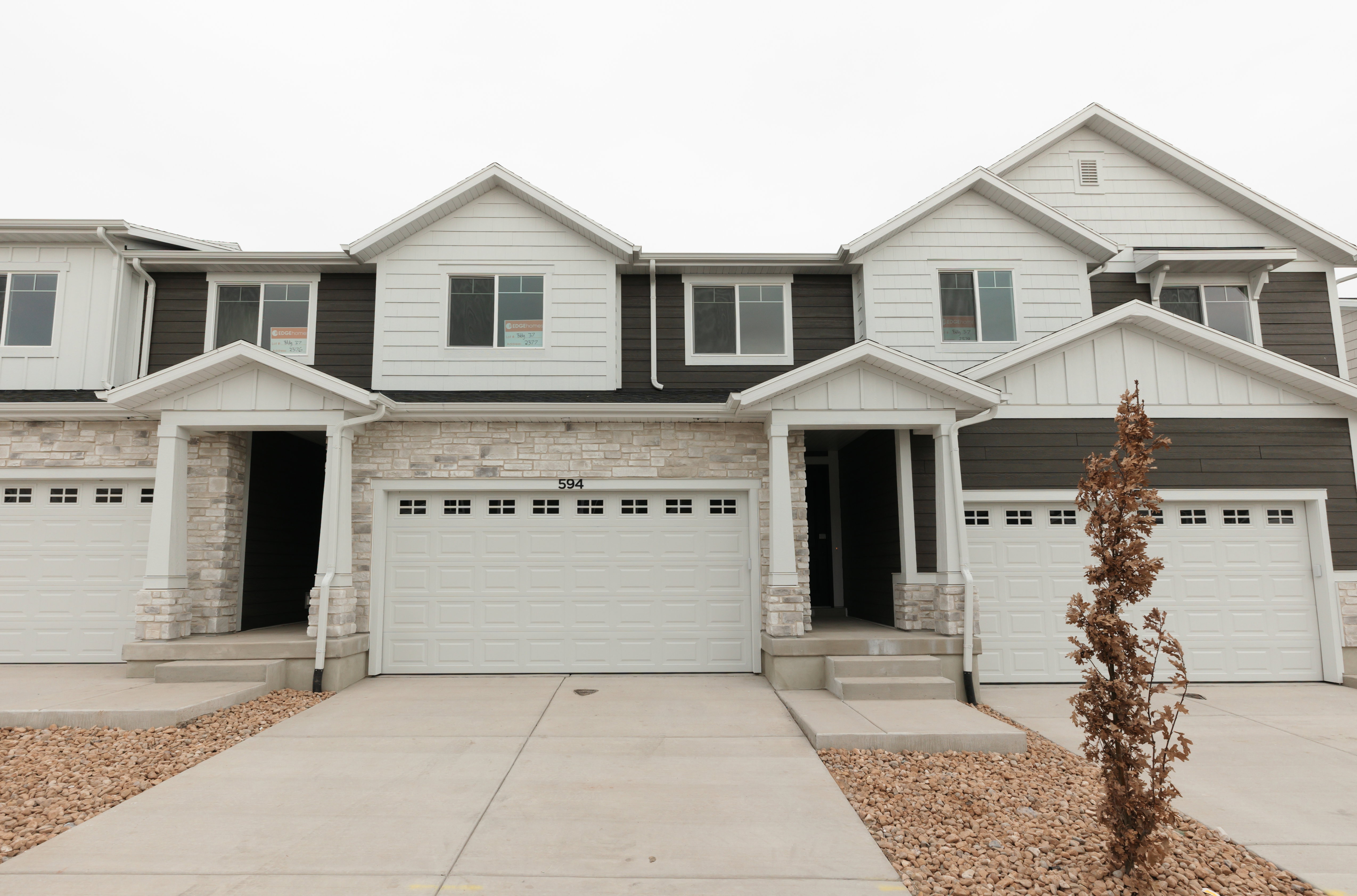 Craftsman-style house with stone siding, board and batten siding, driveway, and a garage