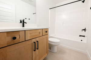 Full bathroom with vanity, tub / shower combination, and light tile patterned floors