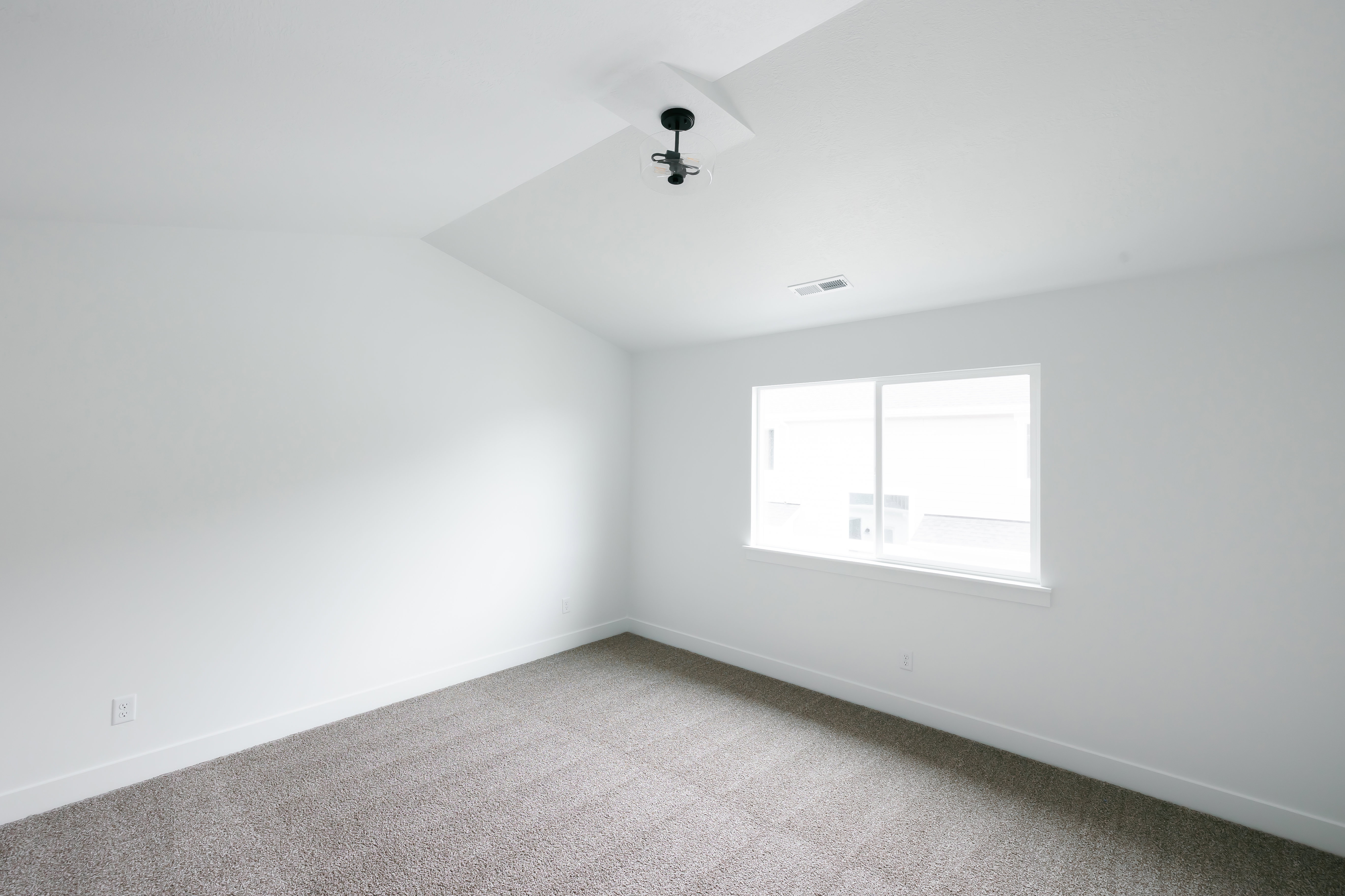Spare room with vaulted ceiling and carpet floors