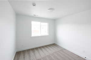 Carpeted spare room with baseboards and a smoke detector