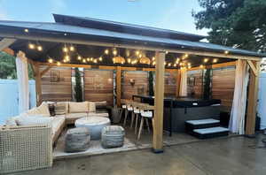 View of patio with a gazebo, a hot tub, and outdoor lounge area