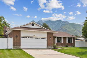 Ranch-style home featuring brick siding, a shingled roof, and driveway