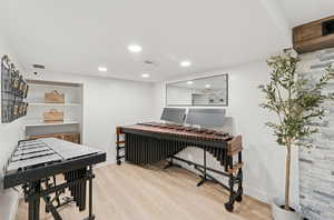 Office with light wood-style flooring and recessed lighting