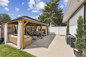 View of patio / terrace featuring a gazebo, a gate, and an outdoor hangout area