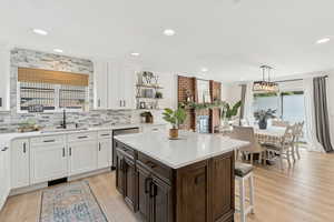Kitchen featuring white cabinets, dark brown cabinetry, pendant lighting, light wood-style floors, and recessed lighting