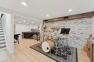 Flex space featuring light wood finished floors, recessed lighting, and an accent wall