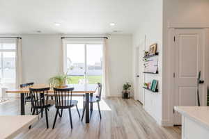 Dining area with light wood-style floors and recessed lighting