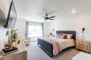 Carpeted bedroom with a ceiling fan