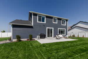 Rear view of property featuring a fenced backyard, a patio, and roof with shingles