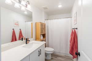 Full bathroom featuring vanity, light wood-style floors, recessed lighting, and a shower with curtain
