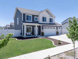Craftsman house with board and batten siding, covered porch, concrete driveway, a garage, and stone siding