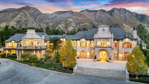 French country home with a chimney, a balcony, a mountain view, and stone siding