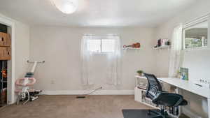Home office featuring baseboards and light colored carpet