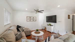 Living room with wood finished floors, a ceiling fan, and recessed lighting