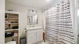 Full bath featuring vanity, shower / bath combination with curtain, and light tile patterned flooring