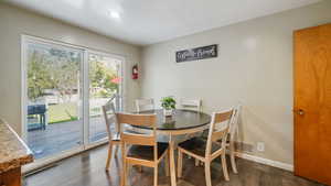 Dining space with dark wood-type flooring and baseboards