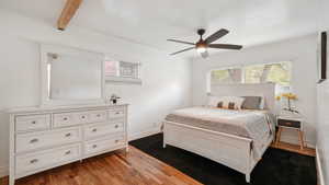 Bedroom with light wood-type flooring, multiple windows, and a ceiling fan