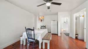 Dining area with dark wood finished floors and ceiling fan