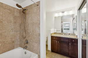 Full bath with shower / bath combination, vanity, and light tile patterned floors