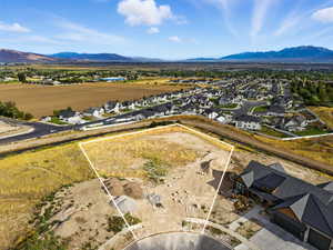 Aerial perspective of suburban area featuring property parcel outlined and a mountain backdrop
