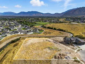 Aerial perspective of suburban area with property parcel outlined and mountains
