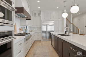 Kitchen with dark brown cabinets, pendant lighting, light wood-style flooring, decorative backsplash, and recessed lighting