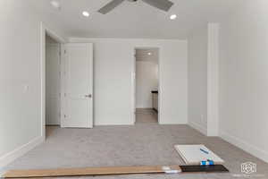 Unfurnished bedroom with light colored carpet, recessed lighting, ensuite bathroom, and ceiling fan